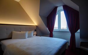 a bedroom with a large bed with a window at Hotel Alina in Wiesbaden +4 photos