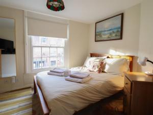 a bedroom with a bed with towels on it at 32 Crescent Street in Newtown