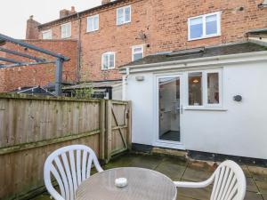 a patio with a table and chairs and a fence at 32 Crescent Street in Newtown