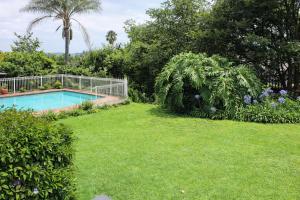 a yard with a swimming pool and green grass at Sunlit Retreat Private Flatlet with Solar Power Pool Fast WiFi & Secure Parking in Roodepoort