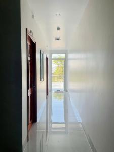 a hallway with white walls and a glass door at Anh Duy Hotel in Nhơn Trạch