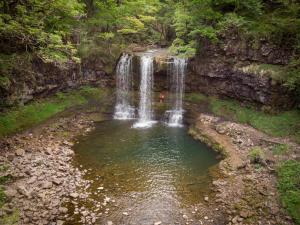 a waterfall in the middle of a pool of water at Mountain Ash Cottage in Mountain Ash