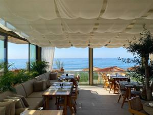 a restaurant with tables and chairs and a view of the ocean at Esentepe Collection Nothern Cyprus Villas & Apartments with Sea View Nothern Cyprus in Pallouriotissa
