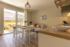 a kitchen and living room with a sink and a table at Appartamenti al Mare - Il Riparo d'aMare in Alba Adriatica
