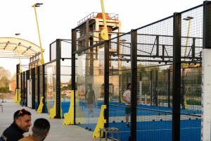 people standing around a tennis court in a batting cage at Gabanon in Casale Monferrato