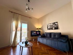 a living room with a blue couch and a tv at Radio House in Myrina