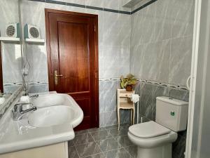 a bathroom with a white sink and a toilet at Chez Gilbert-Alojamento Local in Alqueidão da Serra +21 photos