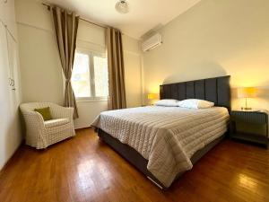 a bedroom with a bed and a chair and a window at Radio House in Myrina