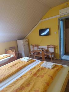 a room with two beds and a table and a tv at Király Szálló in Nagykanizsa +3 photos