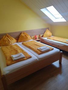 two twin beds in a room with a window at Király Szálló in Nagykanizsa