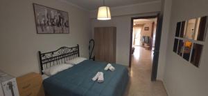 a bedroom with a blue bed with white shoes on it at ARM OV Apartment in Alexandroupoli