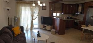 a living room with a couch and a table and a kitchen at ARM OV Apartment in Alexandroupoli