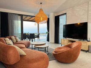 a living room with two couches and a flat screen tv at Esentepe Collection Nothern Cyprus Villas & Apartments with Sea View Nothern Cyprus in Pallouriotissa