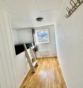 a small room with a window and a ladder in it at Spacious seaside apartment with balcony in Sorreisa