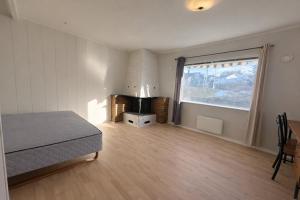 a bedroom with a bed and a large window at Spacious seaside apartment with balcony in Sorreisa