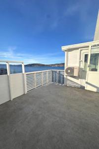 a large deck of a house with a view of the water at Spacious seaside apartment with balcony in Sorreisa