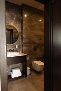 ein Badezimmer mit Waschbecken, Toilette und Spiegel in der Unterkunft Red Baron Hotel & Restaurant in Świdnica + 77 Fotos