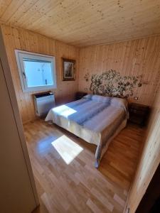 a bedroom with a bed in a wooden room at Bungalow Tirolese in Molina di Ledro