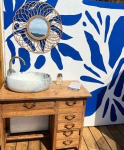 a mirror on top of a wooden dresser next to a wall at Dôme Nissaya in Nice