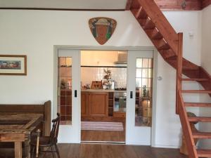 cocina con escalera y comedor en Greenwoods cottage en Valkenburg