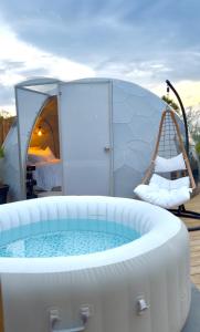 a hot tub in front of a tent with a swing at Dôme Nissaya in Nice