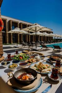 a table with many plates of food on it at Blue Inn Hotel in Gökçeada
