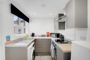 a white kitchen with a sink and a stove at NEW! 4BR in Stanley in Annfield Plain