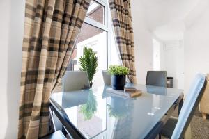 a glass table with two laptops on it in front of a window at NEW! 4BR in Stanley in Annfield Plain