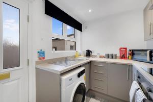 a kitchen with a washing machine and a sink at NEW! 4BR in Stanley in Annfield Plain +40 photos