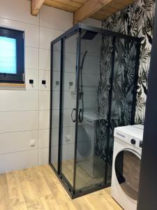 a glass shower in a kitchen with a washing machine at Wrzosowisko Sominki in Sominy +17 photos
