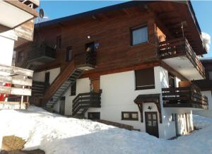 a building in the snow with stairs on it at Jahorina Ski View Apartman in Jahorina