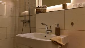 a bathroom sink with a faucet and a mirror at Strandgrün Moderne Ostsee-FeWo am Hansa-Park in Sierksdorf +11 photos