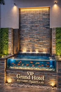 a fish tank in front of a brick wall at VIP GRAND HOTEL- Nearby Trichy Airport & IIM University in Thondamannallūr