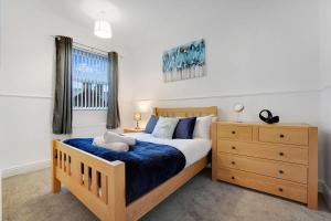 a bedroom with a wooden bed and a dresser at 2-Bedroom Stay with Free Wi-Fi Near Town Centre in Darlington
