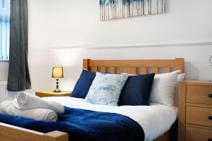 a bedroom with a bed with blue and white pillows at 2-Bedroom Stay with Free Wi-Fi Near Town Centre in Darlington