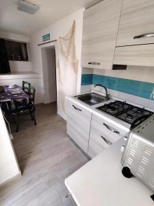 a kitchen with a stove and a sink and a table at Aqua B7 in Cavo