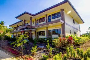 a large house with a lot of plants in front of it at Alta Bohol Resort powered by Cocotel in Tagbilaran City