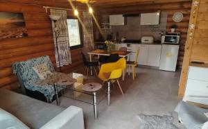 a living room with a couch and a table and chairs at Chatka pod lasem Szczyrk Domek z jacuzzi in Szczyrk