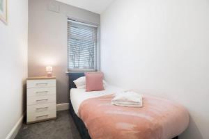 a small bedroom with a bed and a window at NEW! 3BR in Haughton Road in Darlington