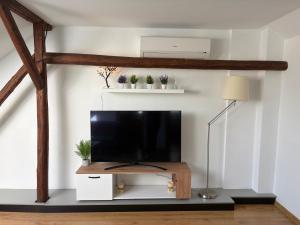 a living room with a flat screen tv on a white wall at Comfy Attic in Pančevo