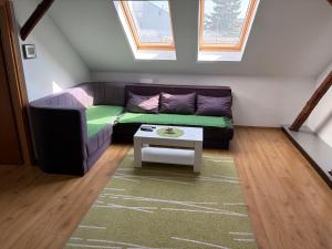 a living room with a couch and a table at Comfy Attic in Pančevo