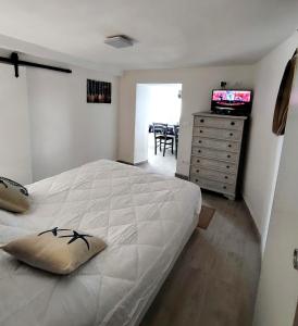 a bedroom with a bed and a dresser with a television at Aqua B7 in Cavo