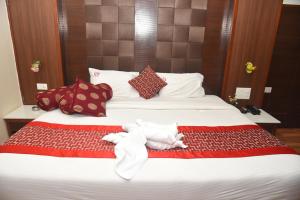 a bedroom with a bed with towels on it at Rd HOTEL ERODE ROAD in Perundurai