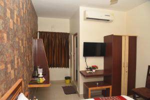 a hotel room with a bed and a tv in it at Rd HOTEL ERODE ROAD in Perundurai