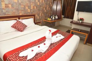 a hotel room with a bed with towels on it at Rd HOTEL ERODE ROAD in Perundurai