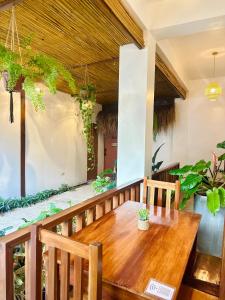 a wooden table and chairs on a balcony with plants at Calathea Suites El Nido in El Nido +21 photos