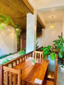 a wooden table and chairs on a balcony with plants at Calathea Suites El Nido in El Nido