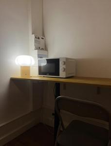 a microwave sitting on top of a table with a lamp at Charmants Appartements au coeur d'Arras in Arras