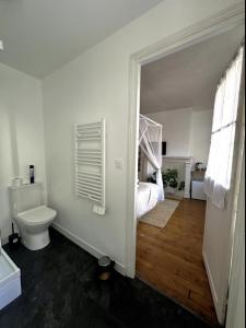 a white bathroom with a bed and a toilet at Charmants Appartements au coeur d'Arras in Arras +74 photos