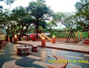 a children play area with a slide and a playground at Blue Park Nature Resort in Mahabaleshwar +7 photos